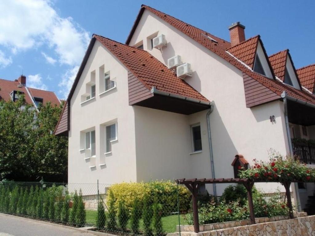 une maison blanche avec un toit rouge dans l'établissement Appartement in Balatonföldvár mit Garten, Terrasse und Grill, à Balatonföldvár