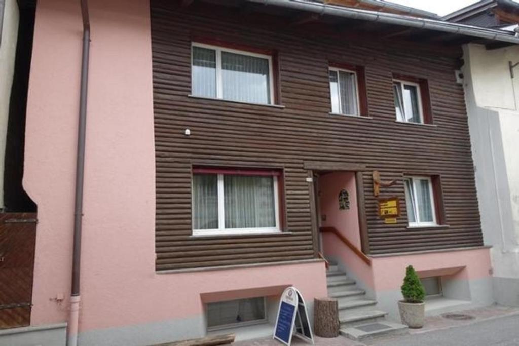 a pink house with a sign in front of it at Unterkunft in Zernez