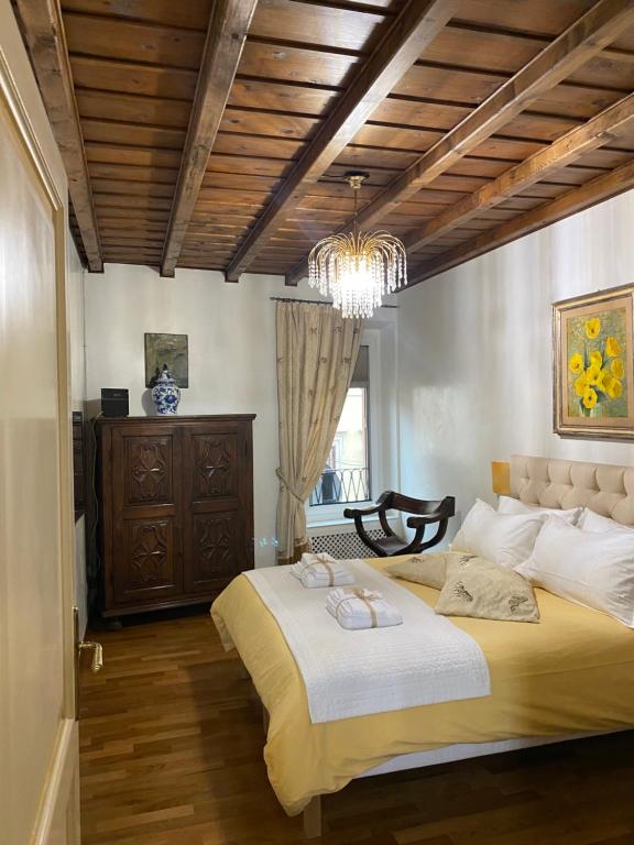 - une chambre avec un grand lit et un lustre dans l'établissement Spanish steps casa Nes, à Rome