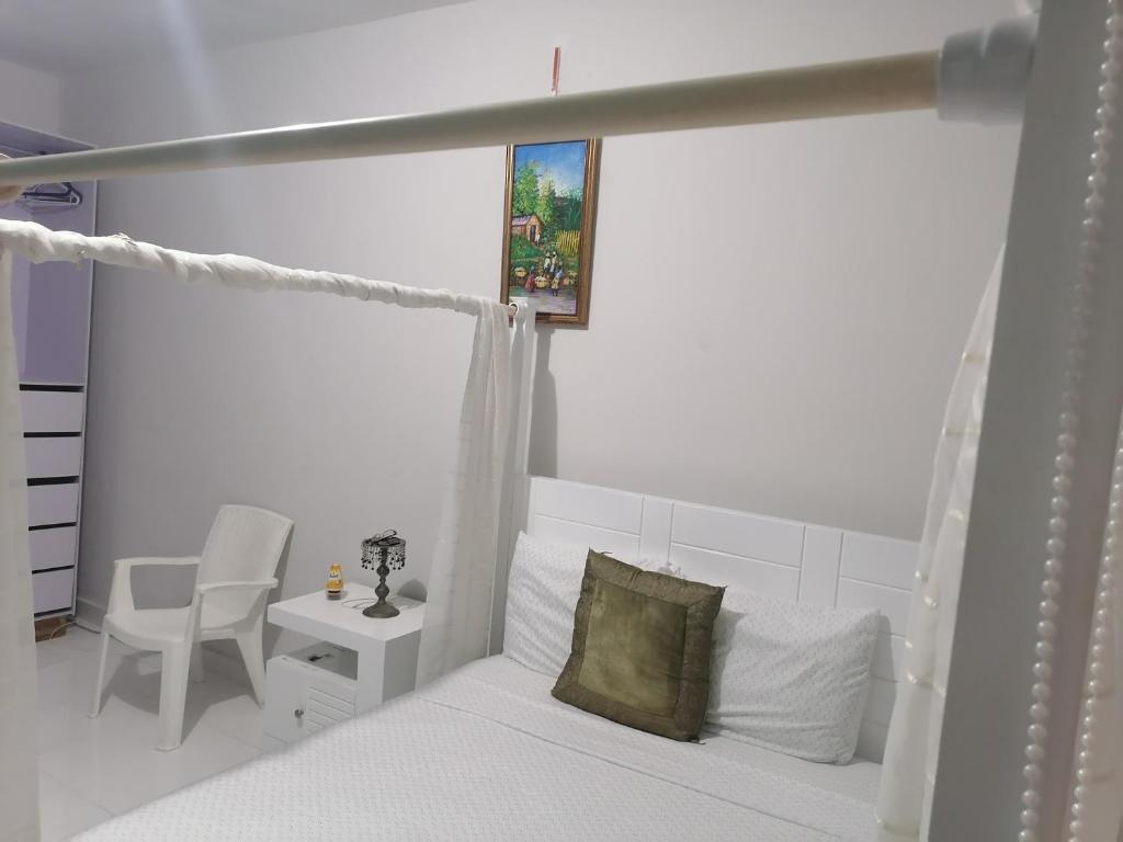 1 dormitorio con 1 cama, 1 silla y 1 ventana en Villa Ada Luxury Retreat en Juan Dolio