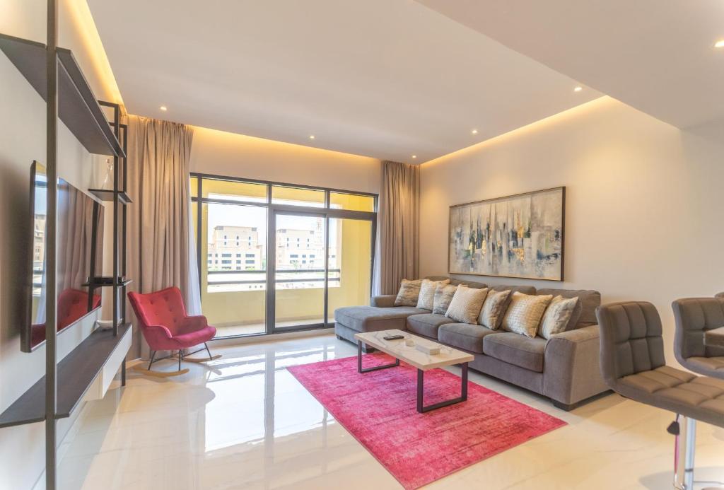 a living room with a couch and a table at Beautifully furnished 3BDR in Al Sidir Greens in Dubai
