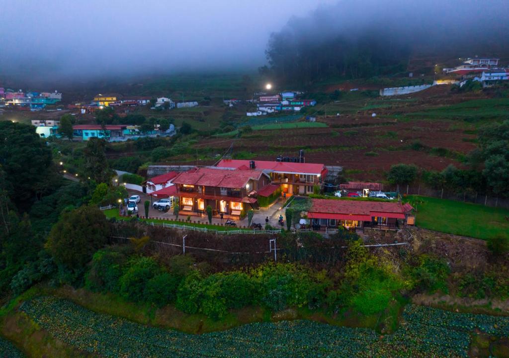 a house sitting on top of a hill at night at Silent Valley Resort Ooty by VOYE HOMES in Ooty