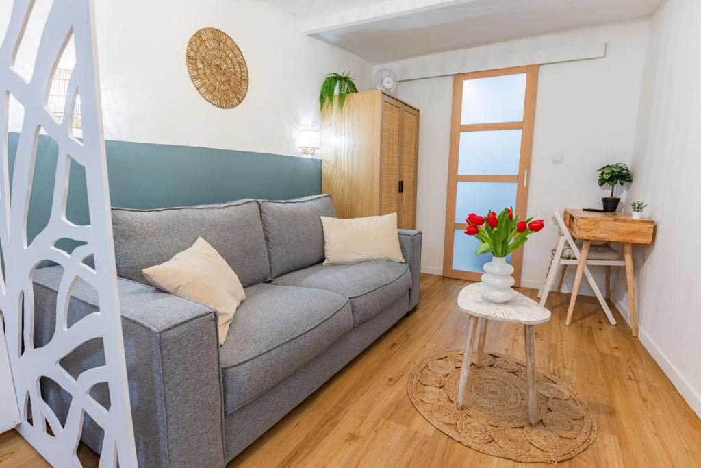 a living room with a gray couch and a table at Studio cozy centre avec Parking in Grasse