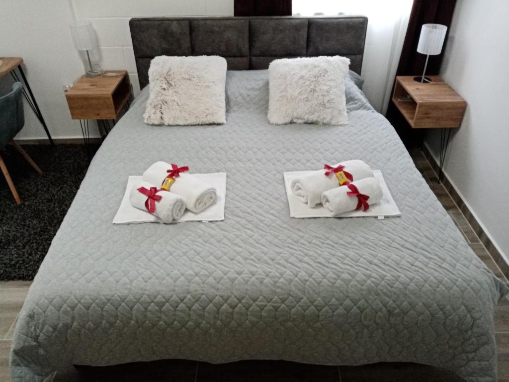 a bed with white towels and bows on it at Studio Pahuljica in Apatin