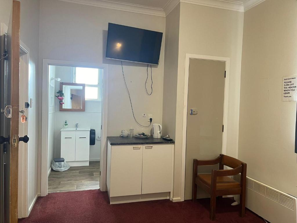 - une cuisine avec un comptoir et une chaise dans une pièce dans l'établissement Oasis Motel - waiouru, à Waiouru