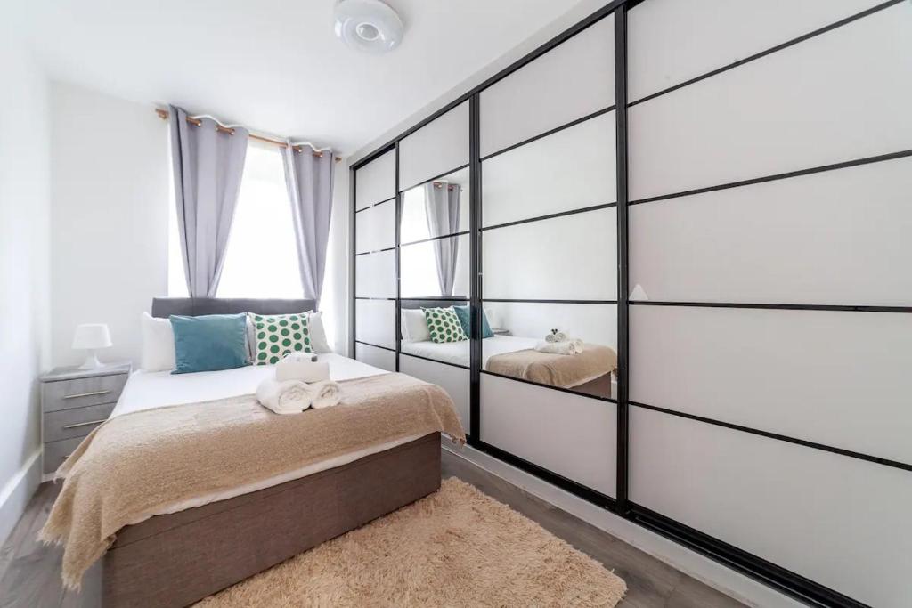 a bedroom with a large wall of glass at Central Ground Floor Flat Free Parking in London