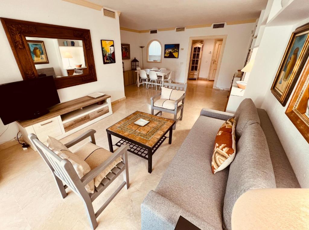 a living room with a couch and a table at Paradis sur le Golf de le Quinta avec accès direct à la piscine in Marbella