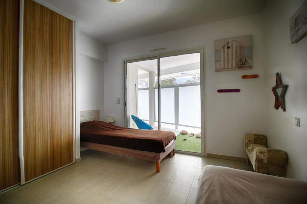 une chambre avec un lit et une grande fenêtre dans l'établissement Appartement Les Rivages Calvi, à Calvi