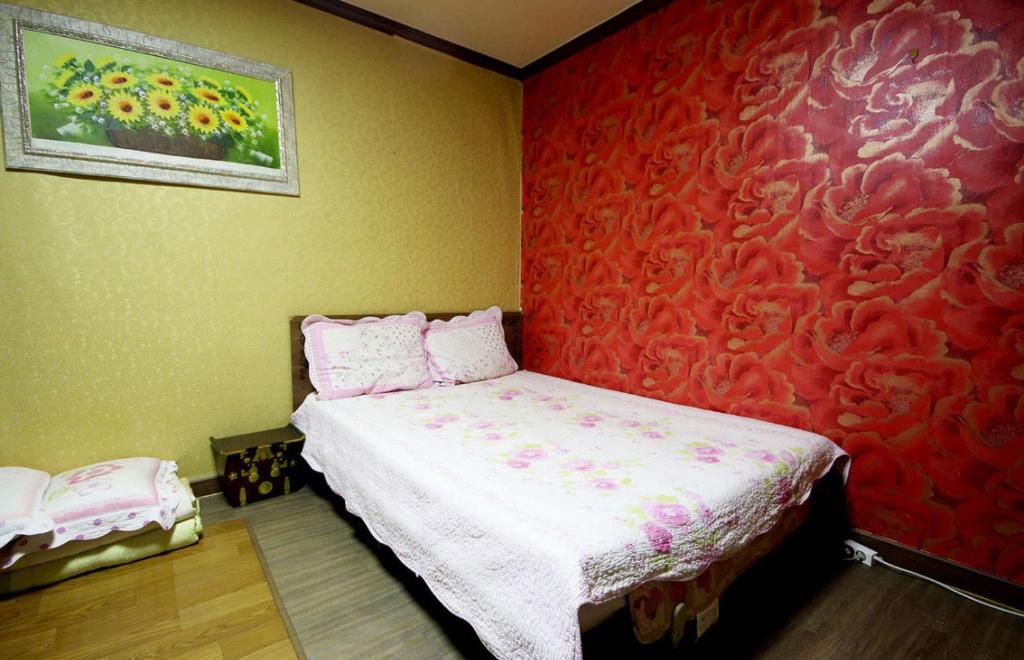 Venus Motel في موكبو: غرفة نوم بسرير بجدار احمر