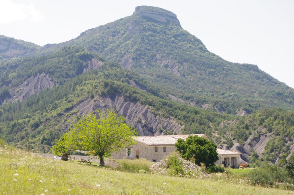 a house on a hill in front of a mountain at Charmante chambre d'hôtes en pleine nature in Orpierre