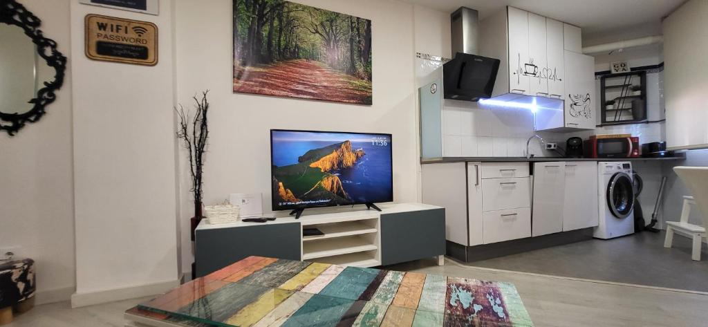ein Wohnzimmer mit einem TV und einer Küche in der Unterkunft www Goyahospitales es in León