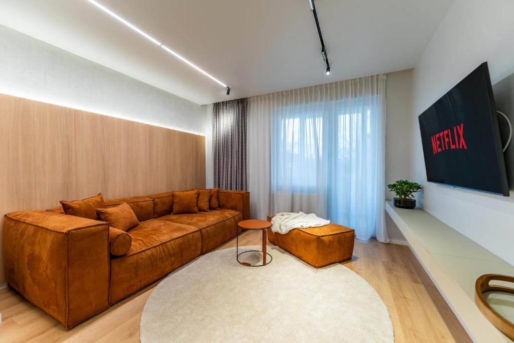 a living room with a brown couch and a table at Kuib Central Apartament in Arad