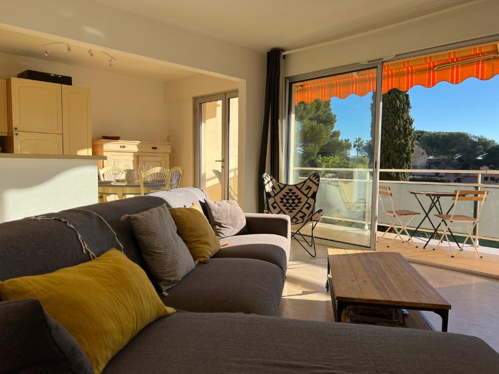 un salon avec un canapé et une table dans l'établissement L'appartement des Cyclades, au Lavandou