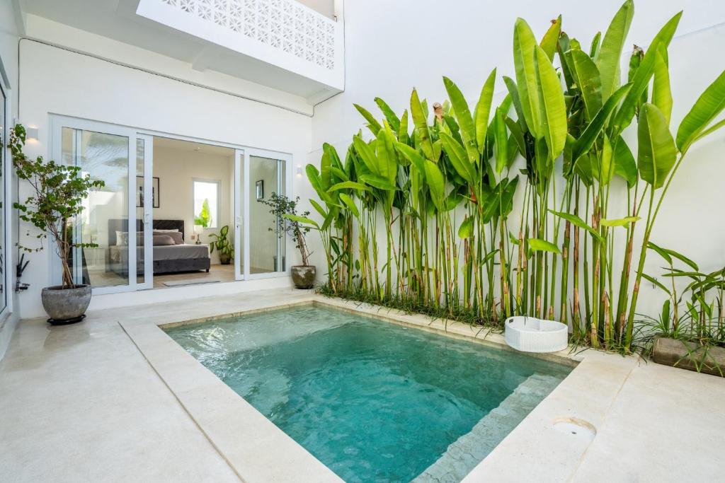 uma piscina num quarto com plantas em Eden Cemagi Villa Mengwi em Mengwi