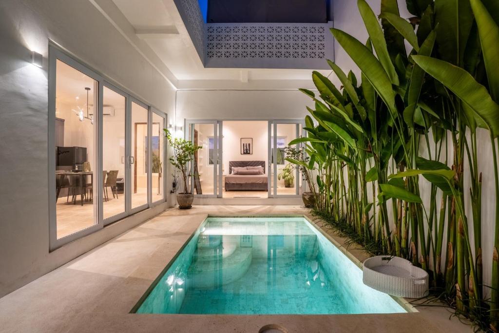 a swimming pool in a house with plants at Eden Cemagi Villa Pererenan in Canggu