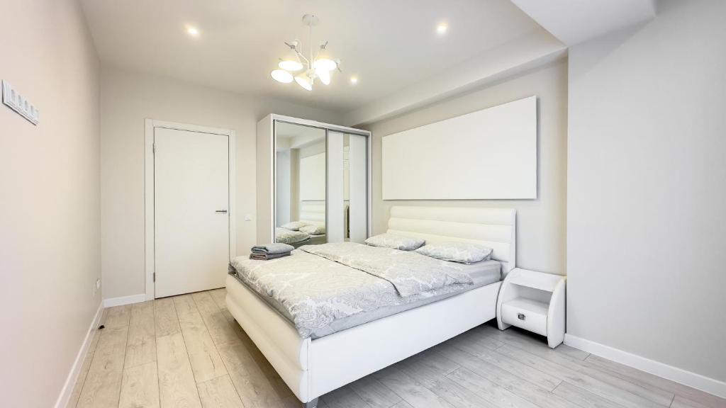- une chambre blanche avec un lit et une grande fenêtre dans l'établissement Ismail Ultracentral Deluxe Apartaments, à Chişinău