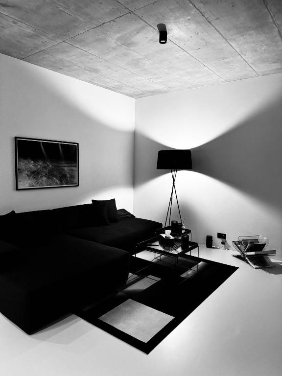 a living room with a black couch and a lamp at Design Flat Hidden Pearl Davos in Davos