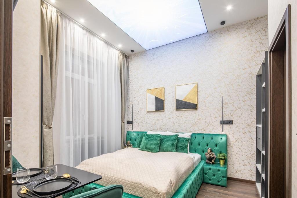 a bedroom with a green couch and a table at Extreme Central - Luxy Stay in Budapest