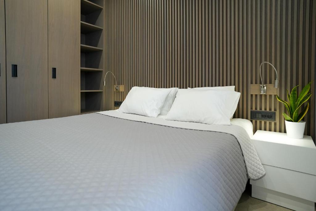 um quarto com uma grande cama branca com almofadas brancas em XeVa Studio em Mastihari