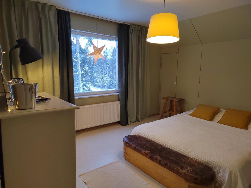 een slaapkamer met een bed en een groot raam bij Villa Puharila in Längelmäki