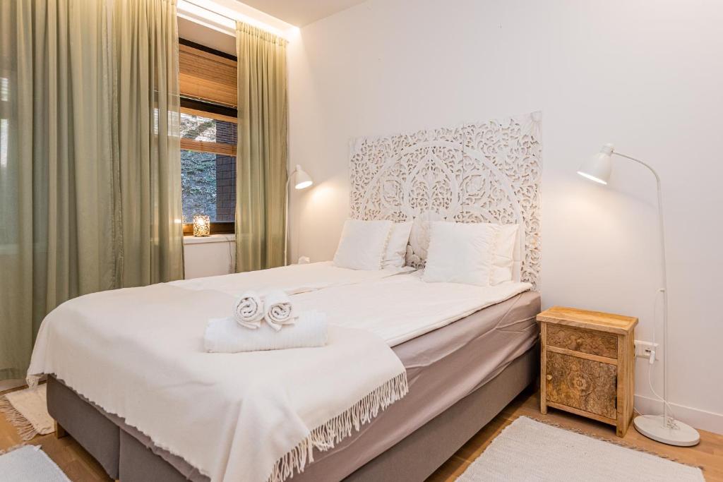 ユオドクランテにあるSmeltė - Family Suite Apartment in Juodkrantėのベッドルーム1室(白いシーツが敷かれた大型ベッド1台、窓付)