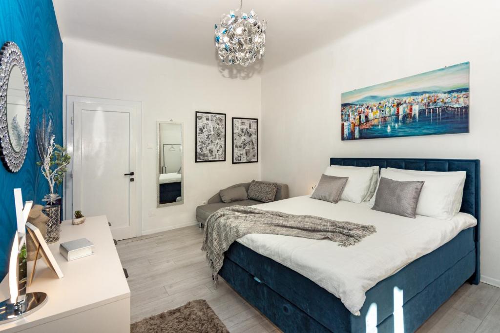 ein Schlafzimmer mit einem großen Bett und einem Kronleuchter in der Unterkunft Spacious Apartment Center in Split