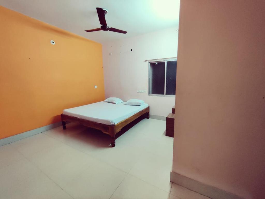 a bedroom with a bed and a ceiling fan at Shivangi Eco in Puri