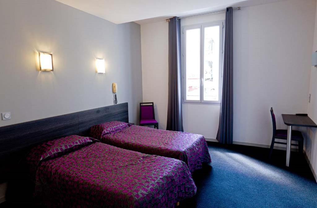 Postel nebo postele na pokoji v ubytování Hôtel Saint Etienne