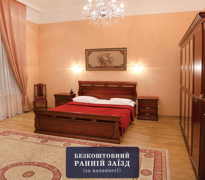a bedroom with a bed and a chandelier at Ekaterina Hotel in Odesa