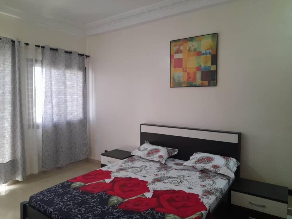 - une chambre avec un lit orné de roses rouges dans l'établissement CHEZ CODOU MEDINA, à Dakar