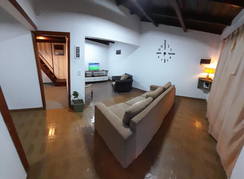 uma sala de estar com um sofá e uma televisão em Home La Pampa em Puerto Iguazú