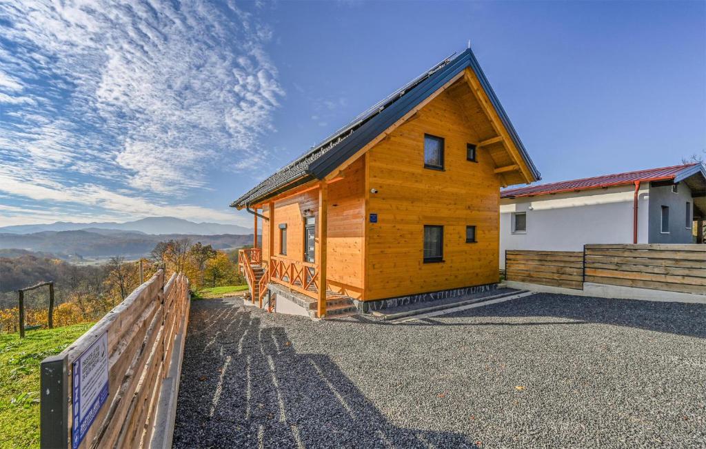 a wooden cabin with a fence in front of it at Awesome Home In Lovrecan With Sauna in Lovrečan