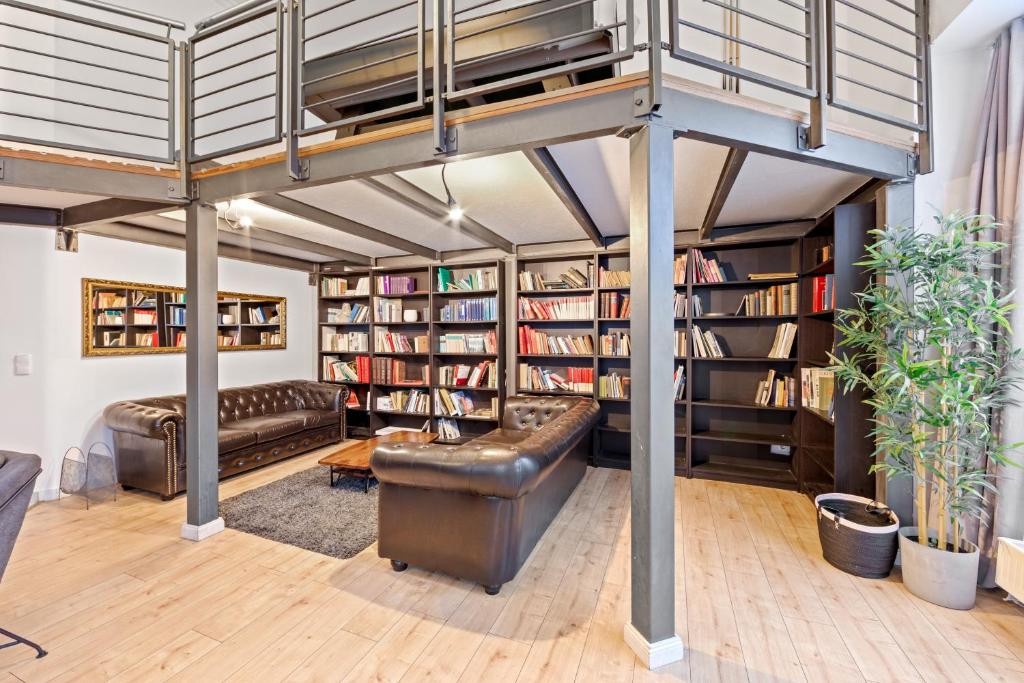 an attic room with a couch and book shelves at Big family apartment Berlin Treptower Park in Berlin