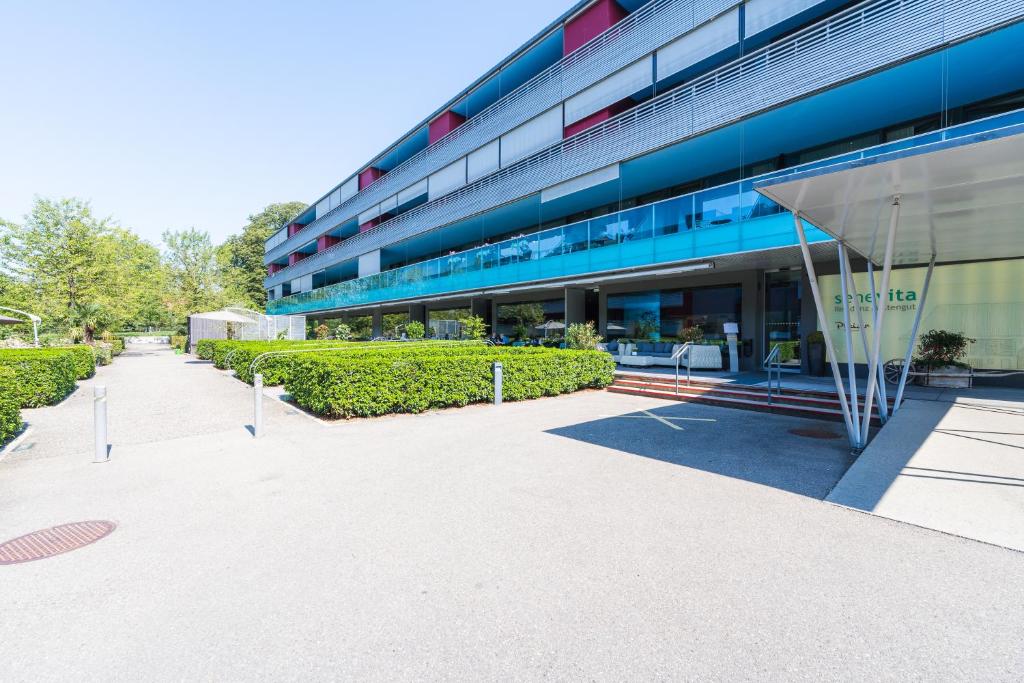 an office building with a glass door and a sidewalk at Senevita Residenz & Apartments Muri bei Bern in Bern