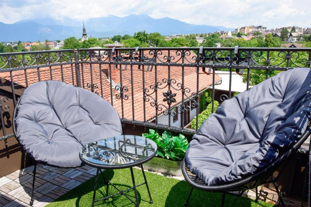 克拉尼的住宿－Apartment in the center of Kranj，阳台上配有两把椅子和一张玻璃桌
