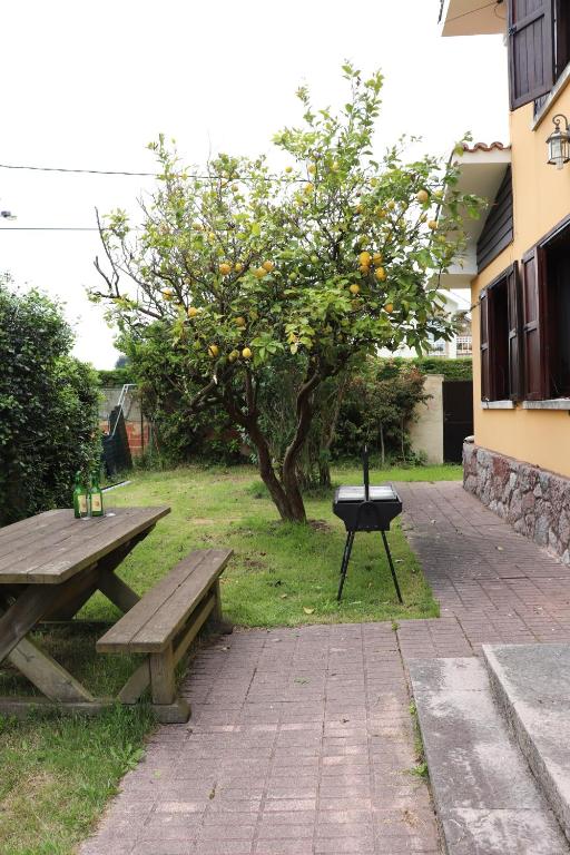 - une table de pique-nique et un grill à côté d'un arbre dans l'établissement Chalet céntrico/costero en Gijón, à Gijón