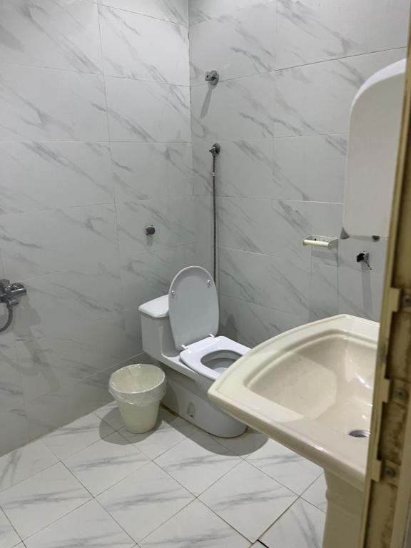 La salle de bains blanche est pourvue de toilettes et d'un lavabo. dans l'établissement فيلا, à Hafr Al Baten