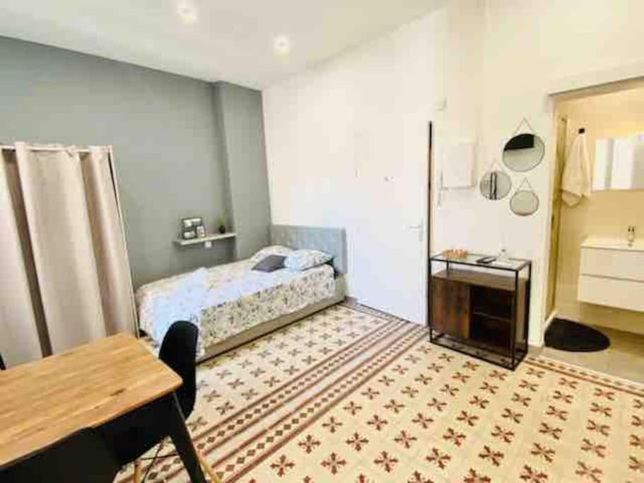 - une chambre avec un lit, une table et un lavabo dans l'établissement Studio confort pour 2 Perpignan Bir Hakeim, à Perpignan