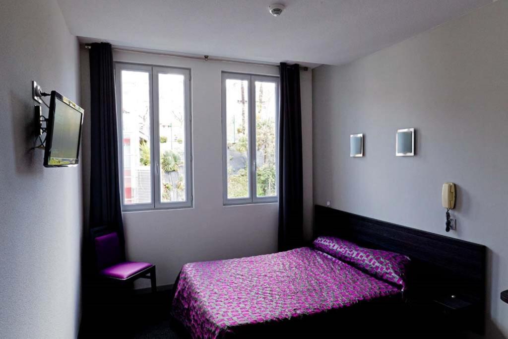 Postel nebo postele na pokoji v ubytování Hôtel Saint Etienne