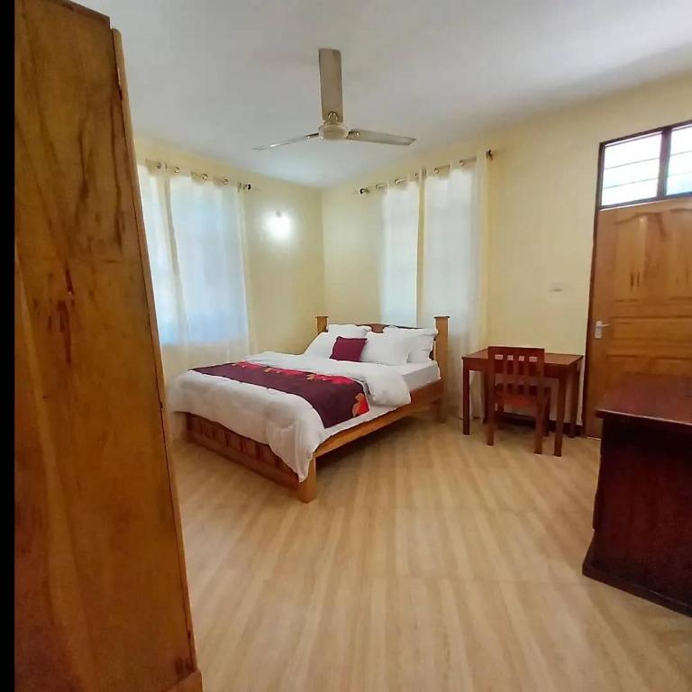 a bedroom with a large bed and a table at Sinthia Apartments 