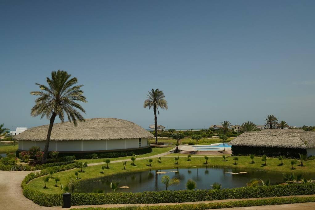 un complejo con un estanque, palmeras y un edificio en Ideal para parejas con niños, junto al mar, en San Pablo