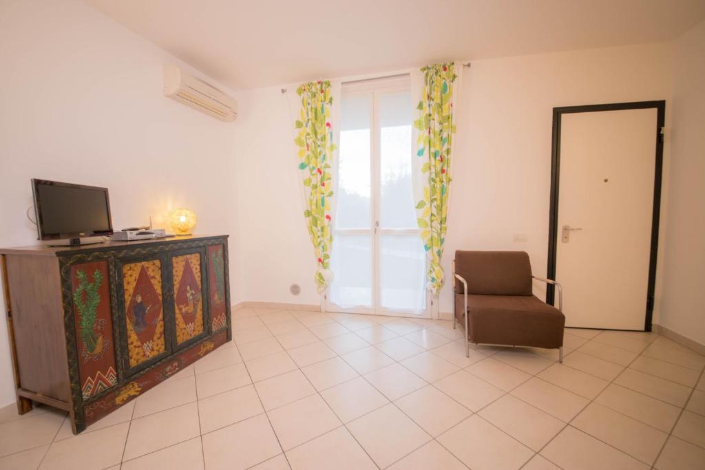 a living room with a chair and a television at Baia Blu RTA Residence in Lerici