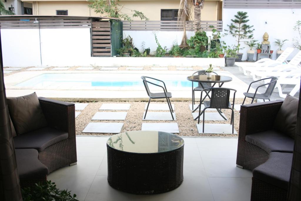 a patio with chairs and a table and a pool at Le Choix- Zil in Grand-Baie