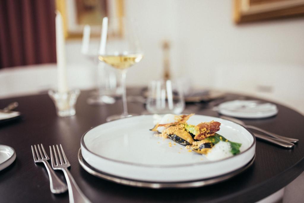 einen Teller mit Essen auf einem Tisch mit einem Glas Wein in der Unterkunft Haus Elisabeth in St. Gertraud im Ultental