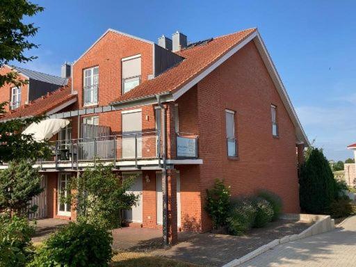 ein großes rotes Backsteingebäude mit einem Balkon in der Unterkunft Strandhaus Fiete - Haus Poelblick - ABC247 in Hohen Wieschendorf