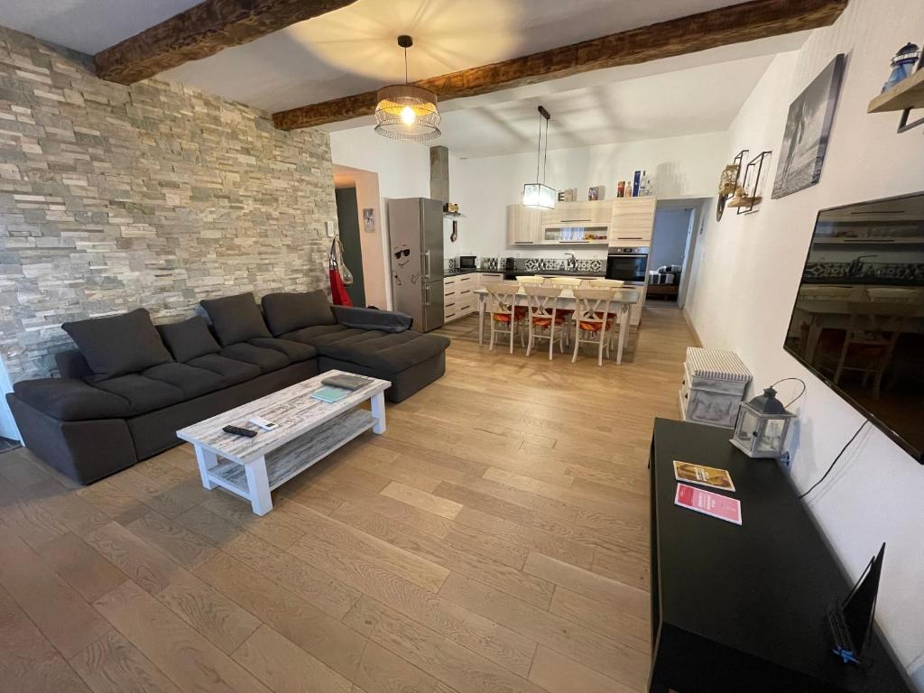 een woonkamer met een bank en een tafel bij Un cocon au cœur du village in Saintes-Maries-de-la-Mer