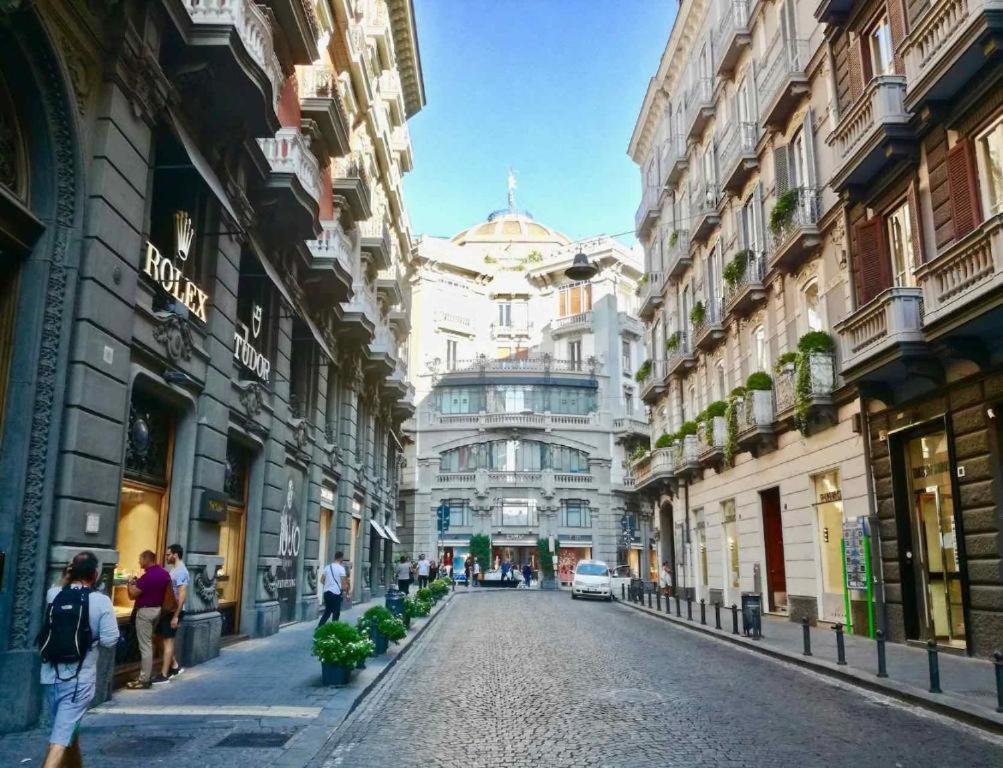 a city street with buildings and people walking on the street at Rodinó rooms in Naples