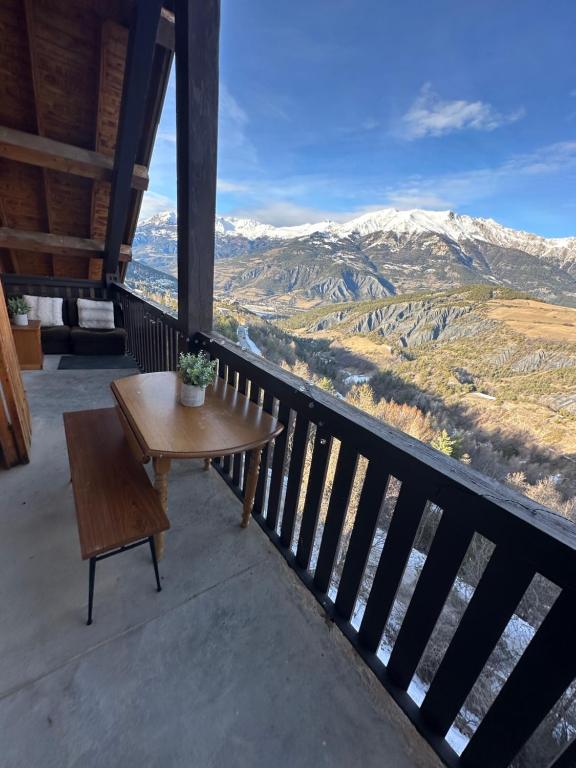 a bench on a balcony with a view of mountains at Appartement au Sauze vue montagne in Enchastrayes