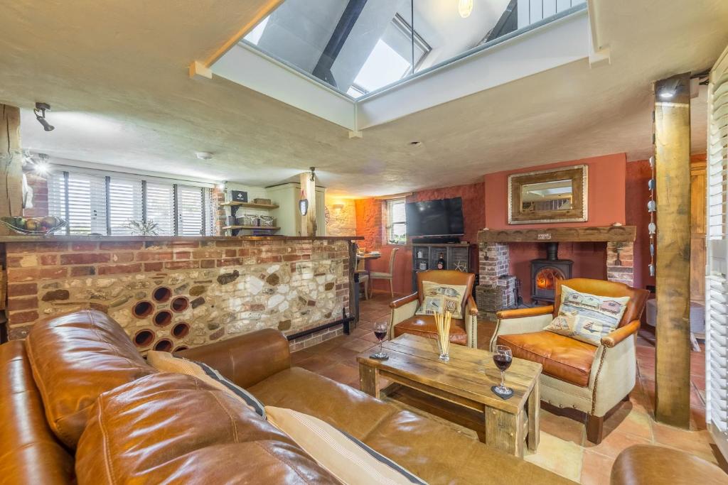 Holme next the SeaにあるThe Old Smithyのリビングルーム(革張りのソファ、暖炉付)