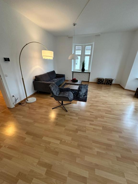 een lege woonkamer met een bank en een stoel bij Gemütliche Ferienwohnung im Herzen von Hameln in Hameln
